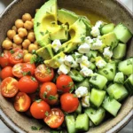 - 1 can (15 oz) chickpeas, rinsed and drained - 1 large ripe avocado, diced - 1 cup cherry tomatoes, halved - 1 cucumber, diced - ½ cup crumbled feta cheese - ¼ red onion, finely chopped - 2 tablespoons fresh parsley, chopped - 2 tablespoons extra virgin olive oil - 1 tablespoon lemon juice - Salt and pepper to taste Each ingredient plays a key role in this salad. The chickpeas add protein and a hearty texture. The creamy avocado brings richness. Cherry tomatoes provide a burst of sweetness. Cucumber adds crunch and freshness. Feta cheese gives that salty, tangy kick. The red onion adds a mild bite. Fresh parsley brightens the dish. Olive oil and lemon juice create a lovely dressing. You can add more depth to your salad. Consider these options: - Bell peppers for crunch and color. - Olives to bring in a briny flavor. - Quinoa for extra protein and fiber. - Nuts like walnuts for crunch. - Spinach or kale for a leafy boost. These add-ins make the salad more filling and fun. Mix and match based on what you have. Freshness makes a big difference in flavor. Here are some tips: - Choose firm avocados that yield slightly when pressed. - Look for bright, plump cherry tomatoes. - Pick cucumbers that are firm and smooth. - Select feta cheese that is creamy, not too dry. - Fresh herbs should be vibrant and fragrant. When you pick fresh ingredients, your salad will taste amazing. Always shop for the best to ensure great flavor and nutrition. To make this salad, gather your ingredients first. You will need one can of chickpeas, a large ripe avocado, cherry tomatoes, cucumber, feta cheese, red onion, parsley, olive oil, lemon juice, salt, and pepper. Start by rinsing the chickpeas under cold water. Drain them well. Next, dice the avocado and cucumber. Cut the cherry tomatoes in half. Finely chop the red onion. In a large mixing bowl, combine the chickpeas, avocado, tomatoes, cucumber, feta, and onion. This mix creates a colorful and fresh base. In a smaller bowl, whisk together olive oil, lemon juice, salt, and pepper. This dressing adds flavor. Drizzle it over your salad mixture. Gently toss everything together. Be careful not to mash the avocado. You want those beautiful chunks to stay intact. Finally, sprinkle the chopped parsley over the top and give it one last gentle toss. You can serve this salad right away. It tastes great fresh. If you have time, let it chill in the fridge for 15 to 30 minutes. This resting time lets the flavors mix well. Serve it as a light lunch, a side dish, or a picnic treat. Enjoy the fresh taste! Handling avocados can be tricky. To avoid bruising, use a gentle touch. Here are some tips: - Choose ripe avocados. They should feel slightly soft when you press them. - Cut the avocado in half lengthwise. Twist the halves to separate them. - Remove the pit with a spoon or carefully with a knife. - Use a spoon to scoop out the flesh gently. This helps keep it intact. - If you have leftover avocado, sprinkle lemon juice on it to prevent browning. To make your salad pop with flavor, try these tips: - Use fresh herbs like parsley for a bright taste. - Add a pinch of salt to enhance the flavors of other ingredients. - Experiment with different oils. A drizzle of infused olive oil adds a nice touch. - Consider adding a dash of vinegar for a bit of tang. - Mix in some spices like cumin or paprika for warmth. A well-presented dish makes eating more fun! Here are some ideas: - Serve the salad in a large bowl for a family-style meal. - Use clear bowls to show off the colors of the ingredients. - Garnish with extra parsley on top for a fresh look. - Add lemon wedges on the side for extra zest. - Arrange the salad on a platter for a vibrant display. With these tips, your Chickpea Feta Avocado Salad will not only taste great but also look amazing! {{image_2}} For a heartier salad, add protein. Grilled chicken or shrimp works well. You can use canned tuna or even boiled eggs for richness. These additions boost the salad's flavor and make it more filling. If you want a vegan option, skip the feta cheese. You can add marinated tofu or a sprinkle of nutritional yeast for a cheesy flavor. These swaps keep the dish tasty and satisfying. Change the ingredients based on the season. In summer, add fresh corn or bell peppers. In fall, try roasted sweet potatoes or butternut squash. These swaps keep your salad fresh and exciting throughout the year. To store your leftover Chickpea Feta Avocado Salad, place it in an airtight container. Make sure to cover it tightly. This keeps air out and helps maintain freshness. If you have extra dressing, store it in a separate container to avoid sogginess. I recommend using glass containers for storage. They are durable and do not stain. They also keep your food fresh. If you prefer plastic, choose BPA-free containers. These are safe and easy to use. Your salad can last 2 to 3 days in the fridge. Keep an eye on the avocado; it can brown quickly. To slow this down, add a little extra lemon juice. This will help keep it fresh and vibrant. Always check the smell and color before eating leftovers. If anything looks off, it’s best to toss it. Chickpeas are a great source of protein and fiber. They help you feel full longer. They also support digestion and heart health. Chickpeas contain vitamins like B6 and folate. These nutrients can help boost your mood and energy. Plus, they are low in fat, which makes them a healthy choice. Yes, you can make this salad ahead of time. Prepare the salad and keep it in the fridge. It tastes even better after chilling for 15-30 minutes. However, if you want to keep the avocado fresh, add it just before serving. This keeps the salad looking bright and tasty. Yes, this salad is gluten-free. All the ingredients, like chickpeas, avocado, and feta, do not contain gluten. It’s a perfect dish for those who avoid gluten in their diet. Enjoy this fresh and flavorful salad without worry! In this blog post, we explored how to make a delicious chickpea feta avocado salad. We discussed key ingredients and optional add-ins to enhance flavor. You learned simple steps for preparation and mixing, along with serving tips. We shared best practices for handling avocados and ways to present your dish. Variations showed how to customize the salad with proteins or seasonal ingredients. Lastly, we covered storage tips to keep leftovers fresh. Enjoy your salad knowing it's tasty, healthy, and perfect for any occasion.